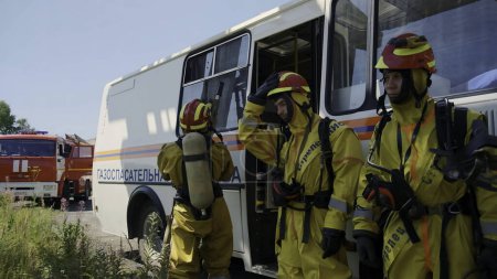 Photo for Serbia - Belgrade, May 20, 2023: Rescue team in yellow protective suits and helmets getting off the bus. Clip. Fire men or rescuers ready for work - Royalty Free Image
