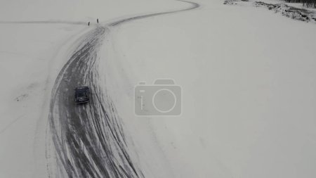 Diversión invernal filmada desde un helicóptero. Clip. Deriva de invierno en los coches que van a las competiciones y la gente mirando alrededor. Imágenes de alta calidad 4k