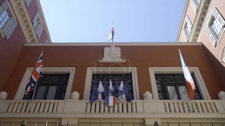 The government building in France. Action. A small red building decorated with flags against the blue sky from above. High quality 4k footage