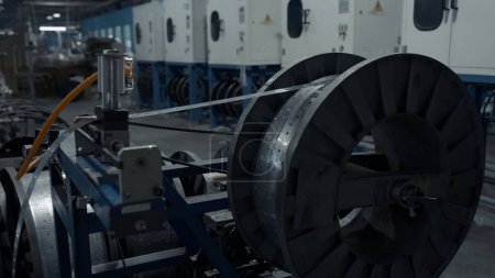Foto de Primer plano de bobina grande giratoria lenta con chapa metálica delgada enrollable. Creativo. Antecedentes industriales en la planta - Imagen libre de derechos
