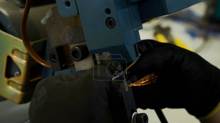 Foto de Cierre de manos obreras haciendo un cable con una máquina especial. Creativo. Formación industrial en un taller de fábrica - Imagen libre de derechos