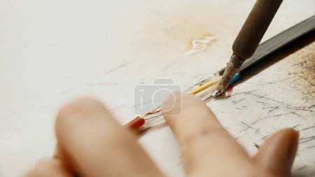 Photo for Soldering iron, wiring repair. Creative. Close up of industrial background of worker in protective gloves repairing a wire - Royalty Free Image