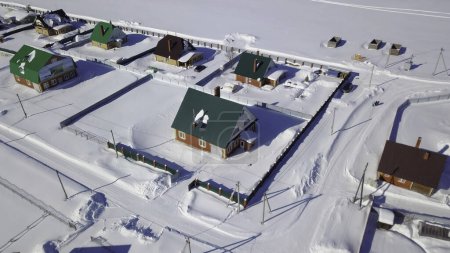 Rural farming community, agricultural fields covered by snow. Clip. Countryside region, winter village with small houses