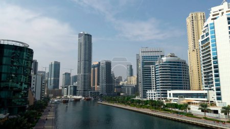 Panoramic view of high buildings with glass facade. Action. Real estate business in united arab emirates and water channel