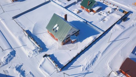 Comunidad agrícola rural, campos agrícolas cubiertos de nieve. Clip. Región de campo, pueblo de invierno con casas pequeñas