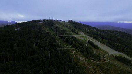 Aerial view of cable cars in mountains. Clip. Travel and outdoor activities, hills, coniferous trees and blue sky