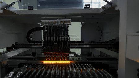 Automatic pick and place machine is installing components on circuit board. Creative. Assembly line on electronics and circuit board manufacturing factory
