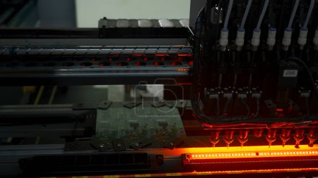 Foto de Línea de montaje totalmente automatizada en la fábrica de electrónica. Creativo. Instalación de componentes en placa de circuito - Imagen libre de derechos