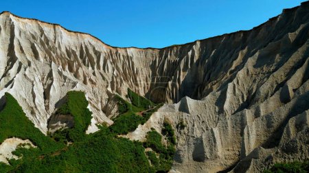 Beautiful aerial of the white cliffs on the south coast of England. Clip. Green summer forested hills and blue sky