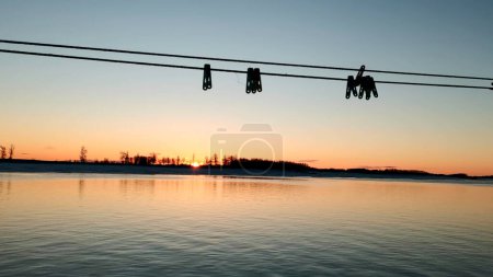 Beautiful sunset and blue sky over a forest lake at evening. Clip. Gentle lake ripples and ropes with clothespins