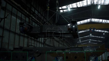 Vista de bajo ángulo de un gran detalle de metal en suspensiones en fábrica. Clip. Sistemas de suspensión con anclajes para el transporte de cargas en fábrica