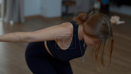Person, die zu Hause Sport treibt. Medien. Frau dehnt Körper, macht Yoga allein zu Hause