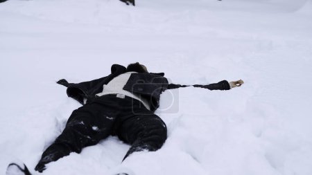Happy young man in fairytale winter forest lying on snow. Media. Concept of religion and feeling unity with nature