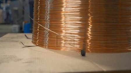 Photo for Close-up of wound copper wire in production. Creative. Thin line of wire on industrial coil. Production of copper wire at metallurgical plant. - Royalty Free Image
