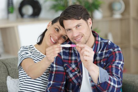 happy couple holding pregnancy test