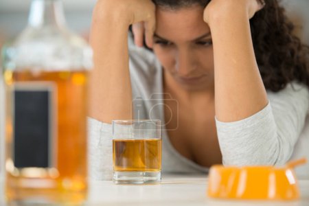 mujer joven en depresión bebiendo alcohol