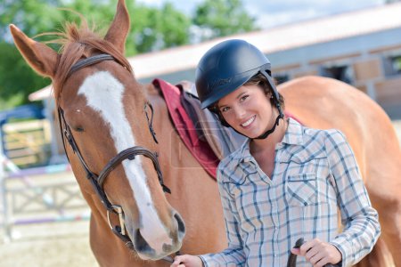 Retrato de la mujer que lleva sombrero de montar, con caballo