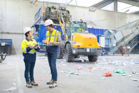 two workers talking in a recycling center