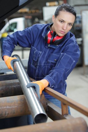 female handling machinery in a metal workshop