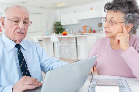 elderly couple using laptop at home