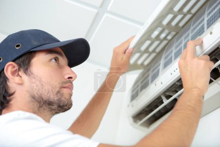 airconditioning technician inspecting the filter