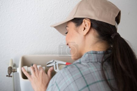 female plumber repairing toilet flush