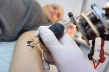 un tatooer está haciendo tatoo