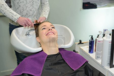 glückliche Frau bekommt eine Haarwäsche vom Friseur