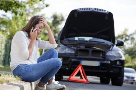 woman with a broken car calling for assistance