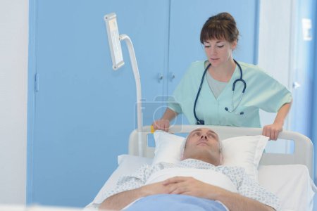 infirmière roue patient dans lit d'hôpital