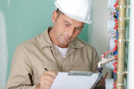 technician reading the water meter to check consumption