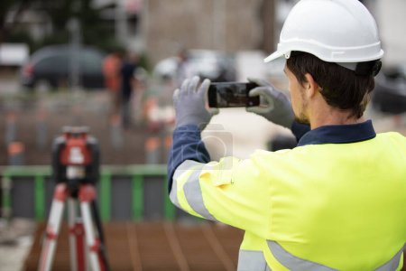 geometer on a construction site taking measurements