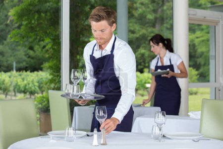 Camarero poniendo la mesa en un restaurante de lujo

