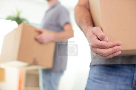 cropped view of removals men carrying boxes