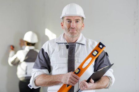 portrait of builder with professional level