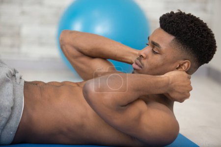 healthy man exercising abdominals on foor