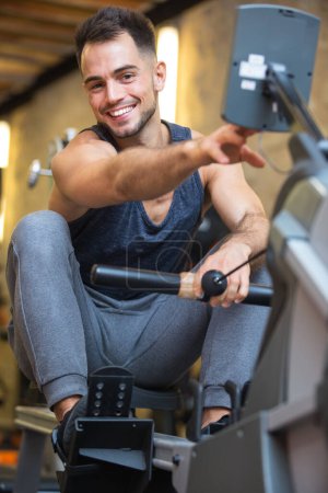 happy man exercising on rowing machine