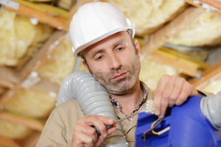 man holding ventilation system in property under renovation