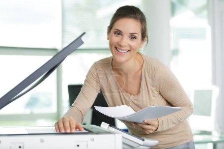feliz joven secretaria mujer haciendo fotocopias en la oficina