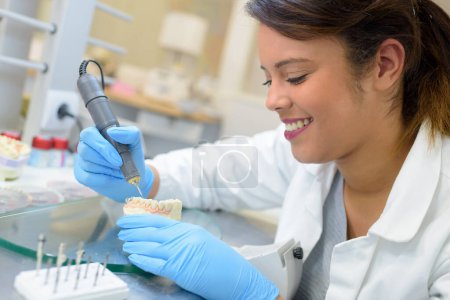 dental technician using drill to prepare dentures