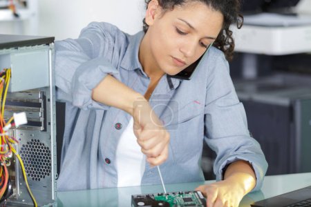 female worker screwing a computer piece