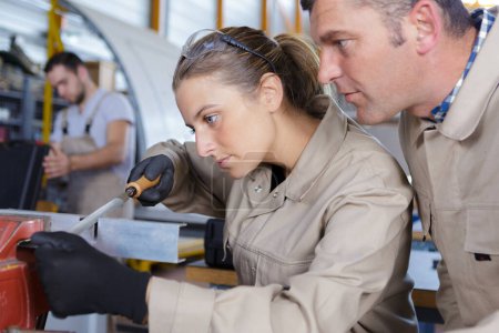 female mechanic and man working near an aircraft in hangar