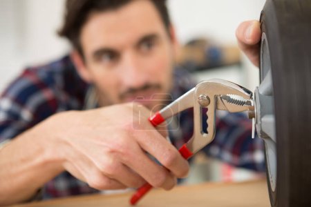 man using pliers to place a split pin