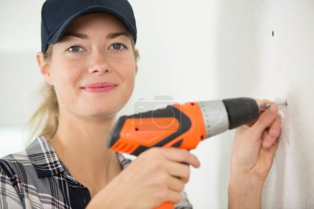 female carpenter using a drill on a wood