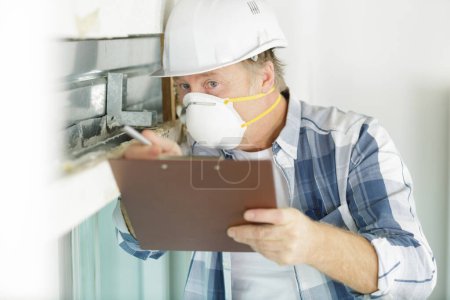 man wearing dust mask making report on renovation property