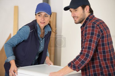 hombre y mujer entregando lavadora