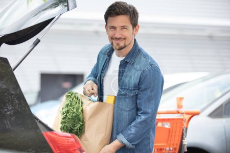 husband putting groceries in the car