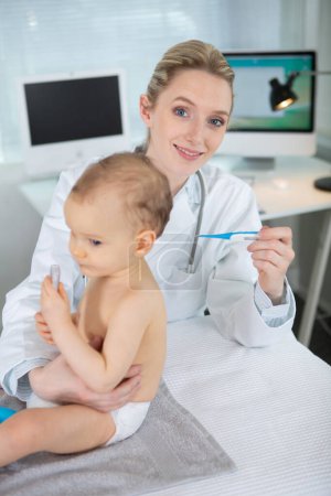 doctor measuring temperature cute baby
