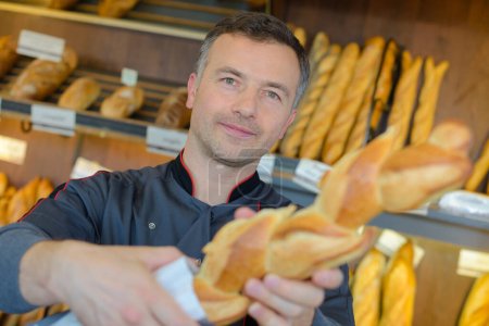 bakery shopkeeper is proud of his bread production