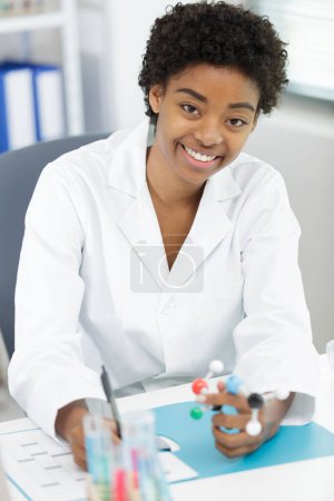 portrait of female scientist holding model molecule